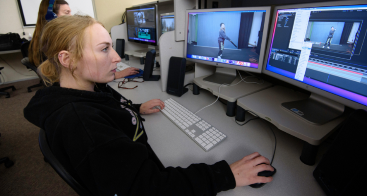 two female students in computer lab editing video footage