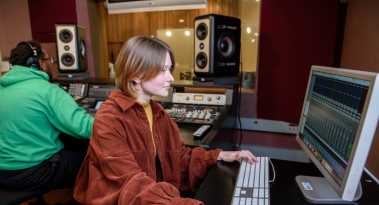 lady and man in recording studio at controls