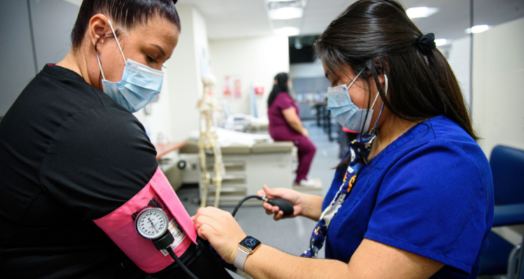 female healthcare working taking patient blood pressure in a clinic