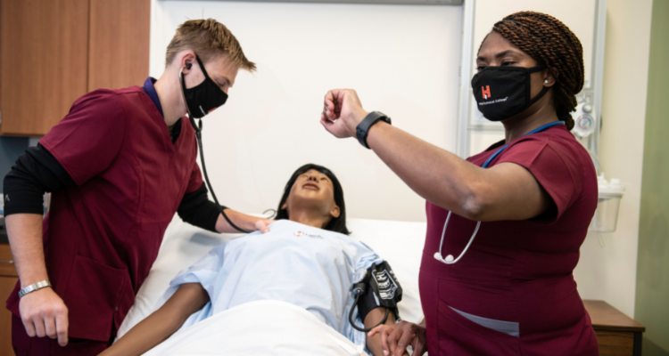 female and male nursing students evaluating health of dummy patient