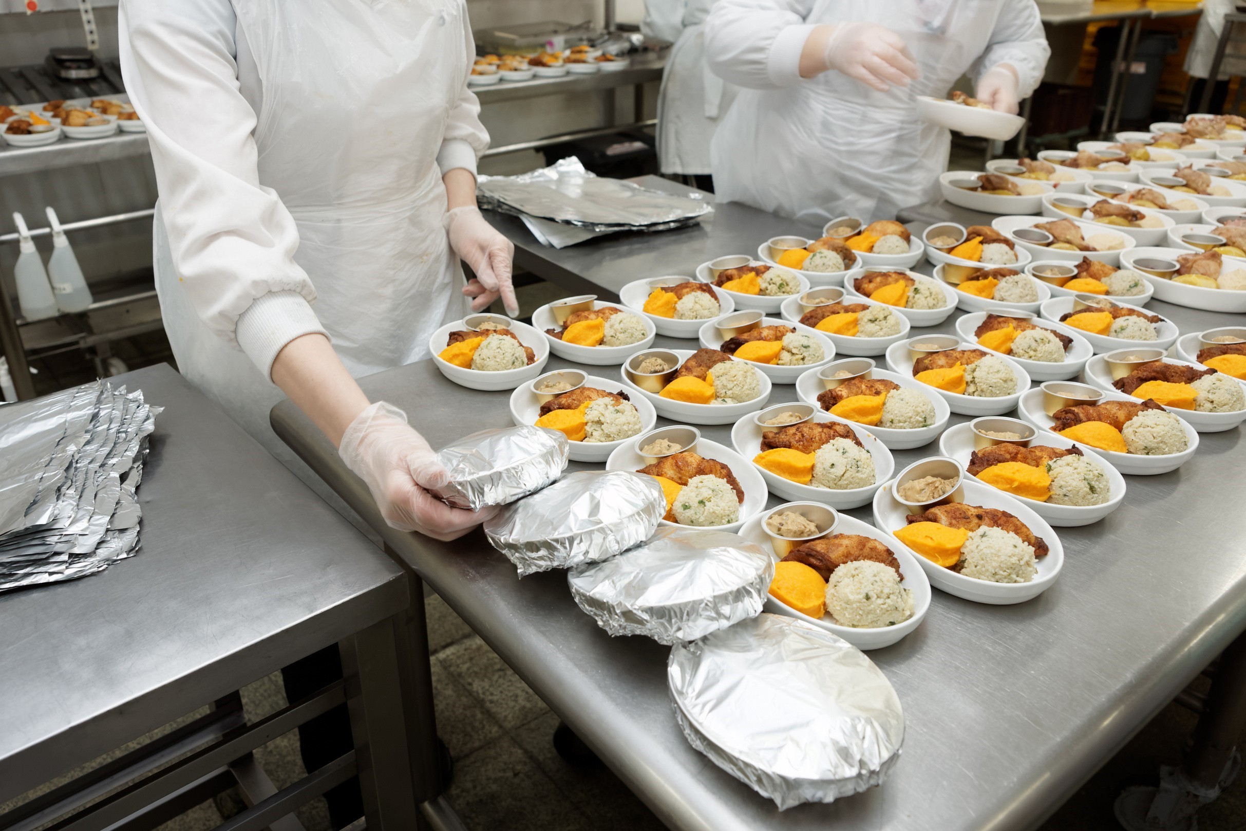kitchen workers preparing packaged meals