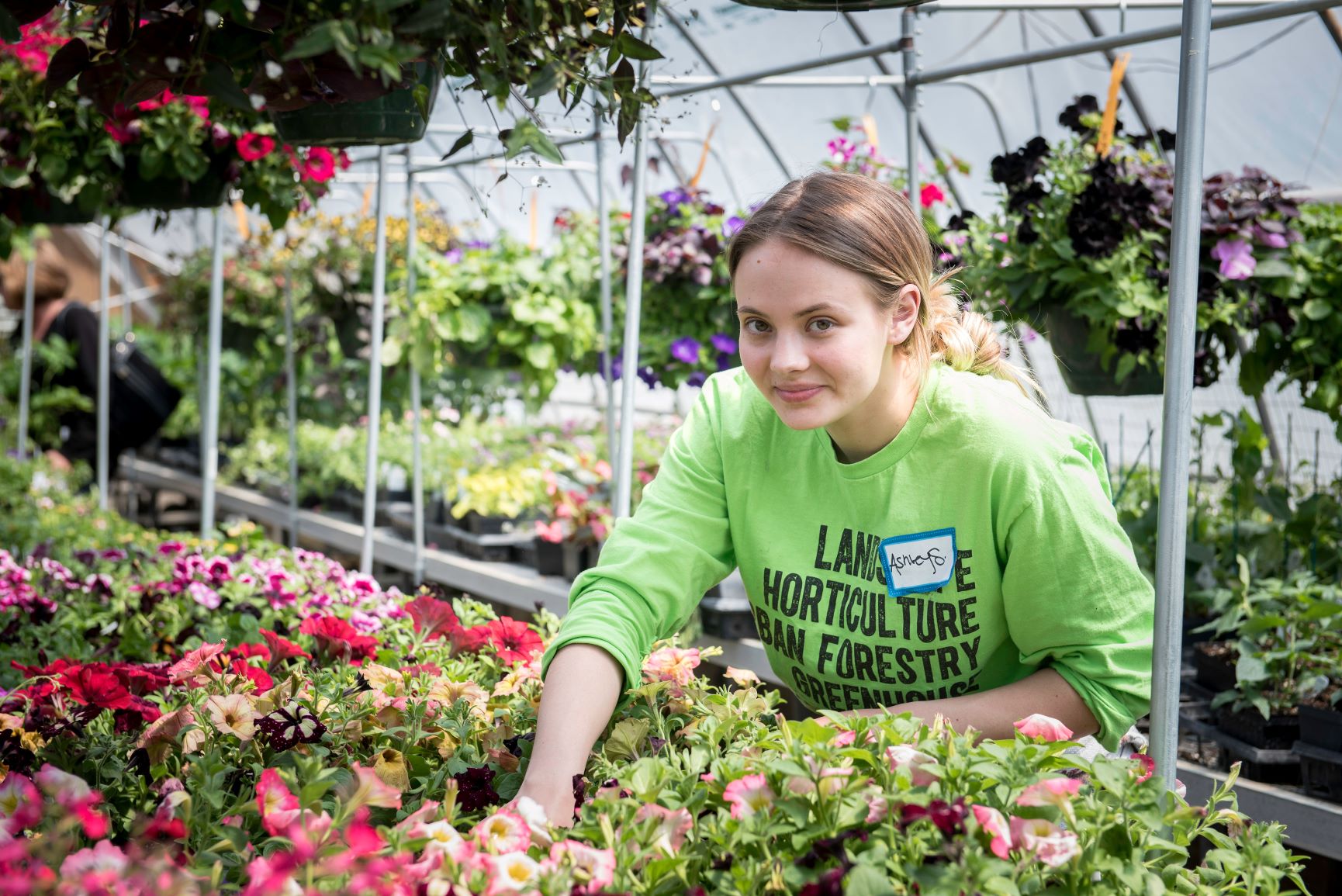 female greenhouse student working with plants