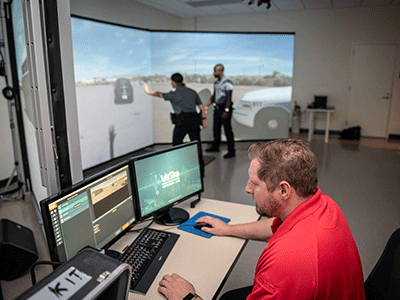 man operating simulator with police cadets practicing skills
